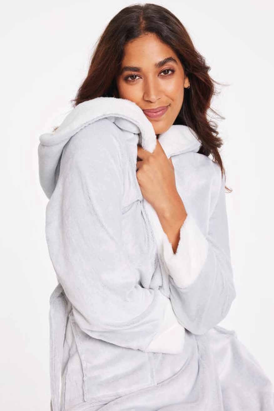 Model wearing a soft white robe, holding a baby